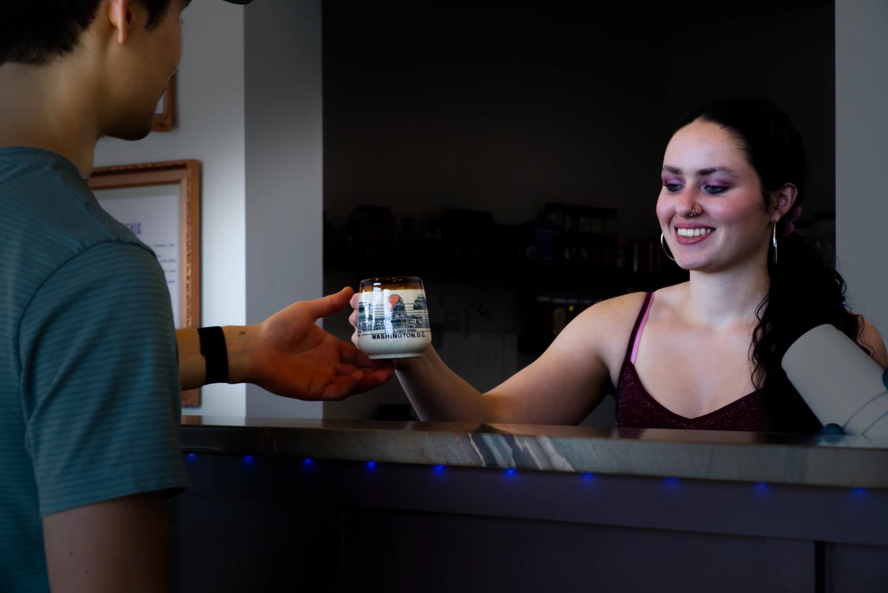 Barista handing a drink to a member at Bowl Time coffee bar